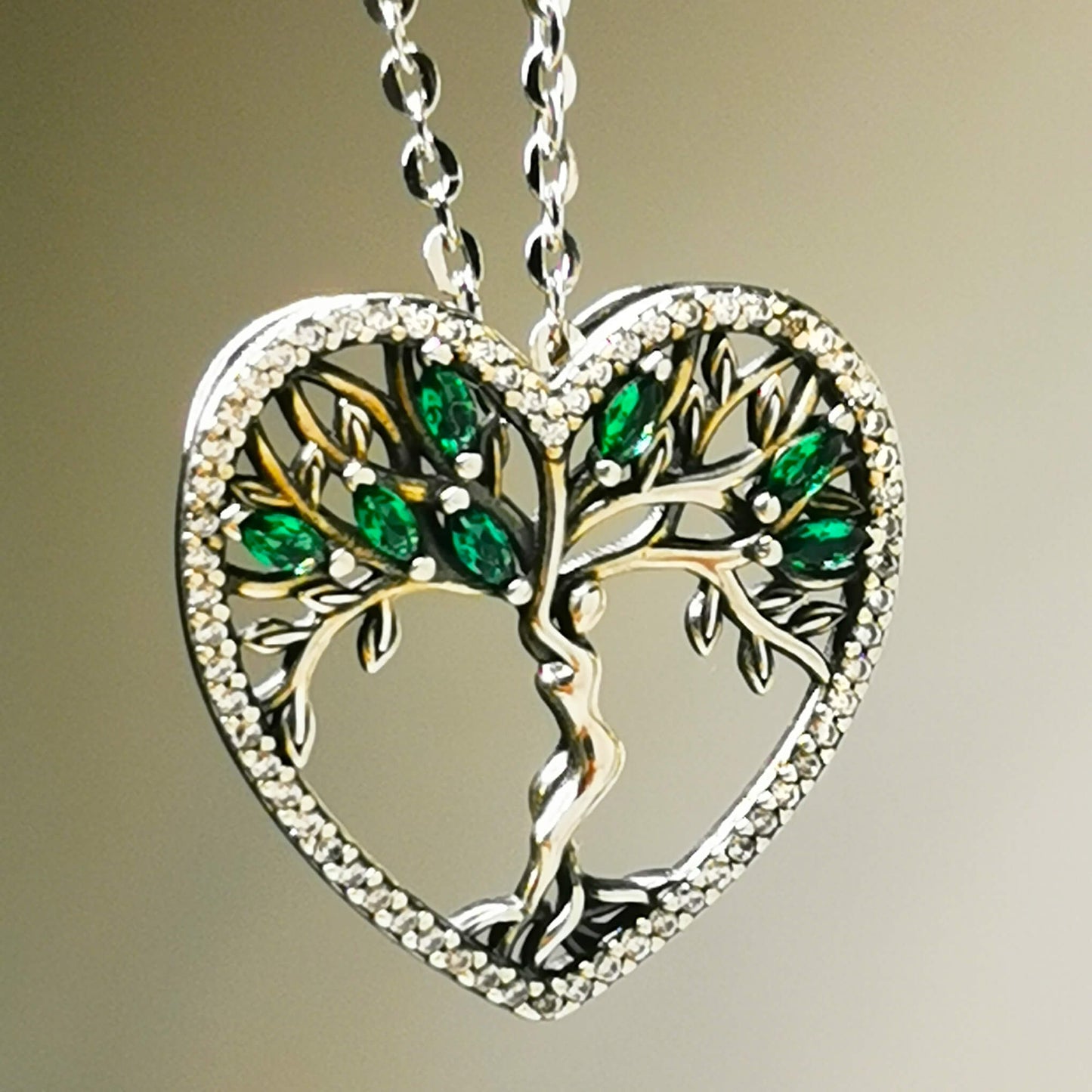 High quality detailed sterling silver tree of life pendant necklace with green zirconia and micro cubic zirconia heart shape edge. 