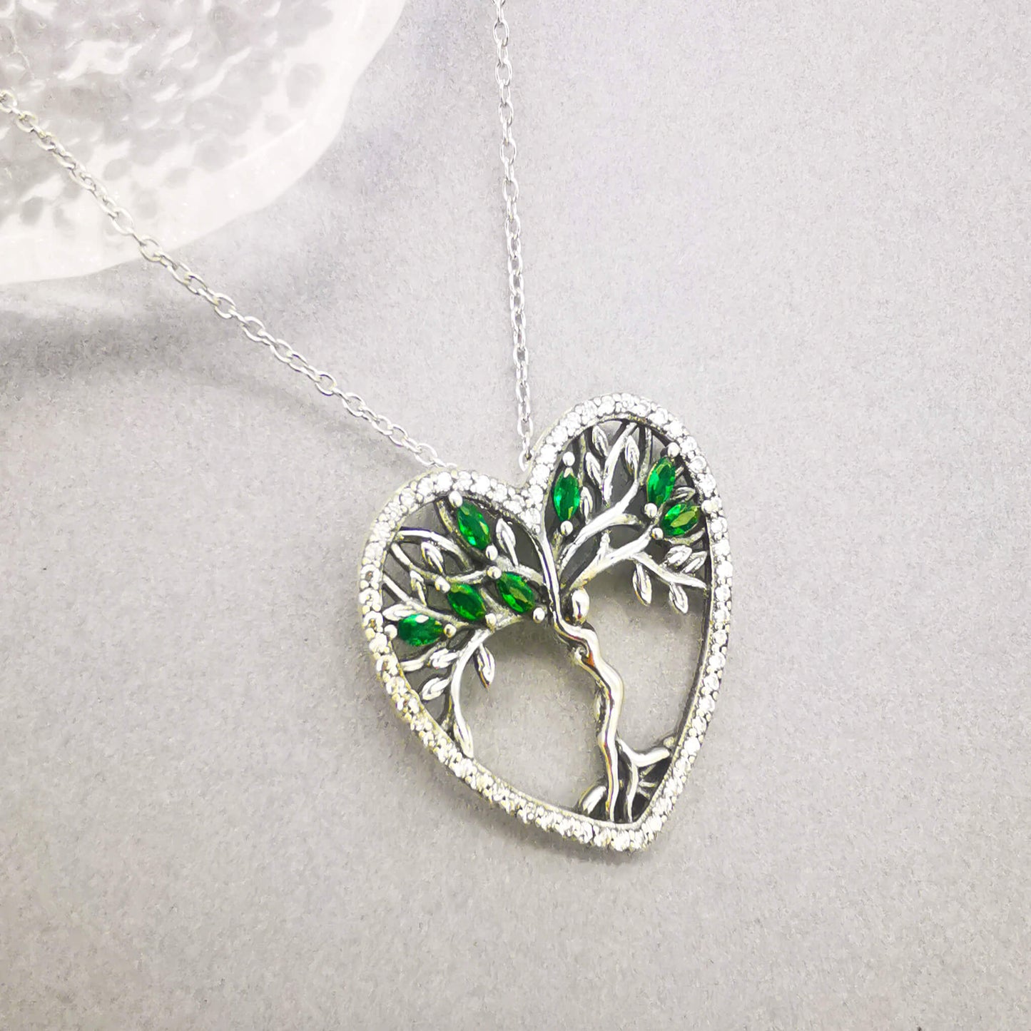 High quality detailed sterling silver tree of life pendant necklace with green zirconia and micro cubic zirconia heart shape edge. 