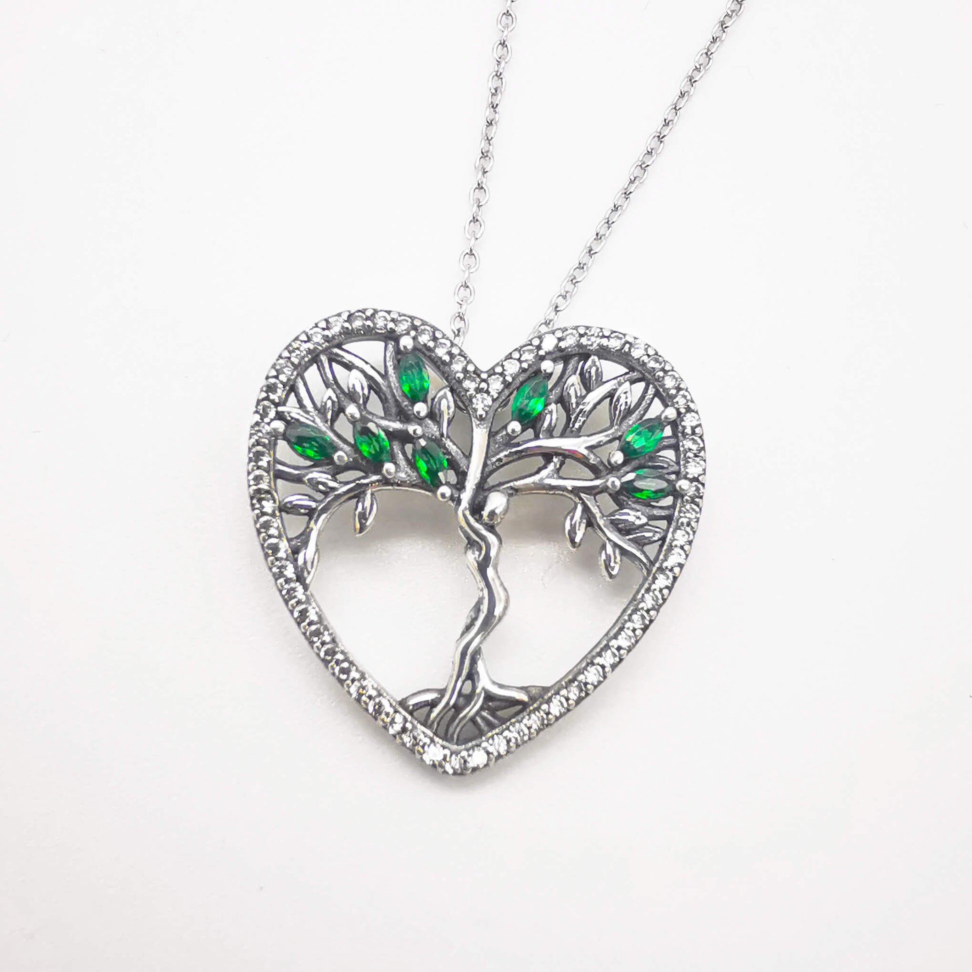 High quality detailed sterling silver tree of life pendant necklace with green zirconia and micro cubic zirconia heart shape edge. 